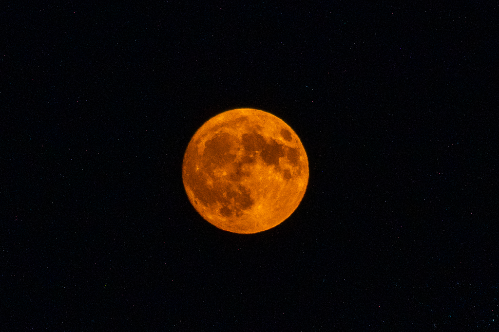 Pleine lune orangée dans un ciel noir, photographiée le 28 juillet 2026.